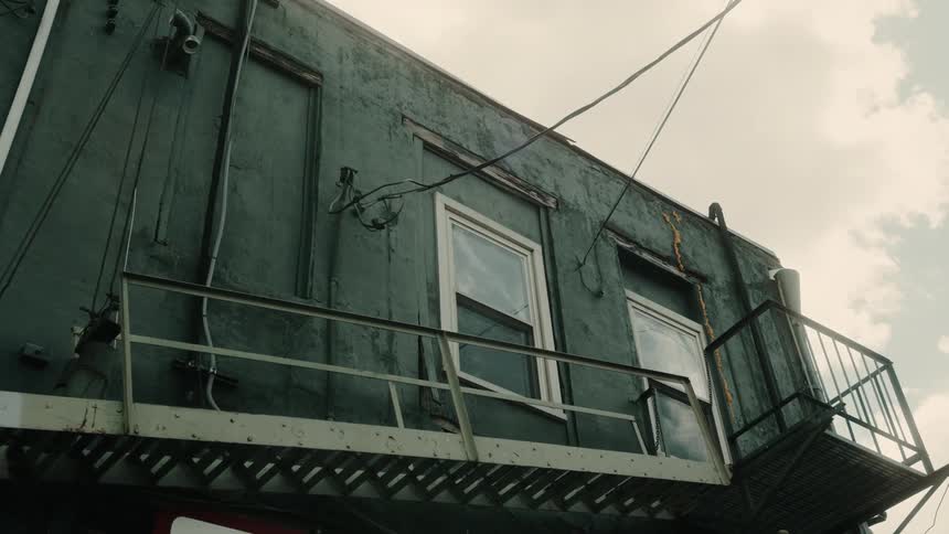 An old construction trailer sits under a cloudy sky