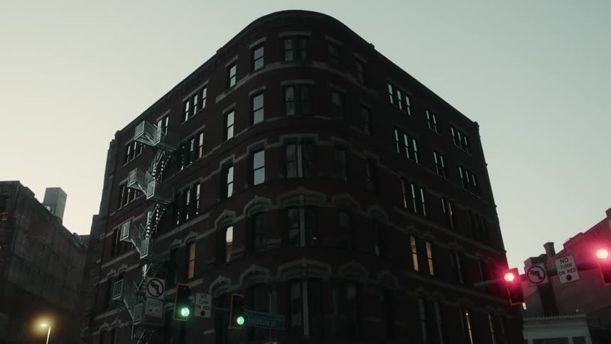 Building on the corner with stoplights nearby at sunrise