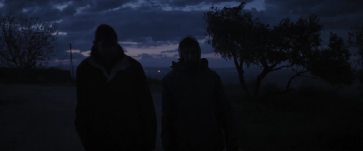 Two people walking in the dark