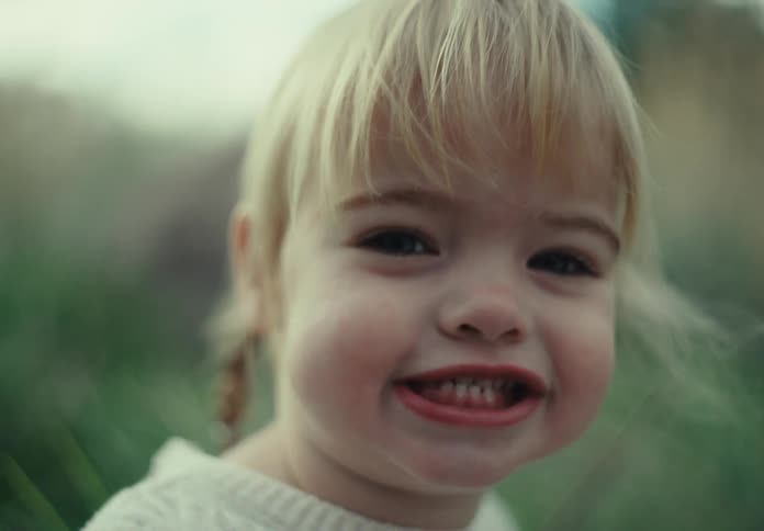 A child is playing with a blade of grass
