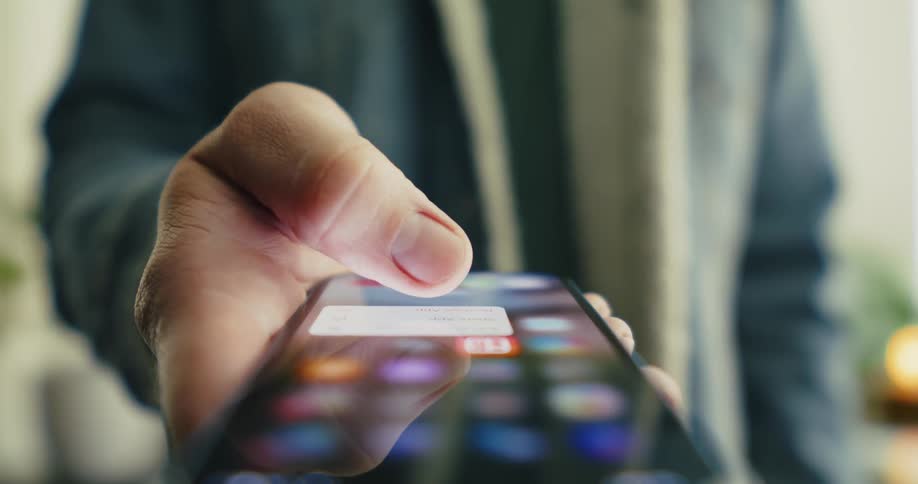 Person holding a smartphone with the screen visible and deleting an app