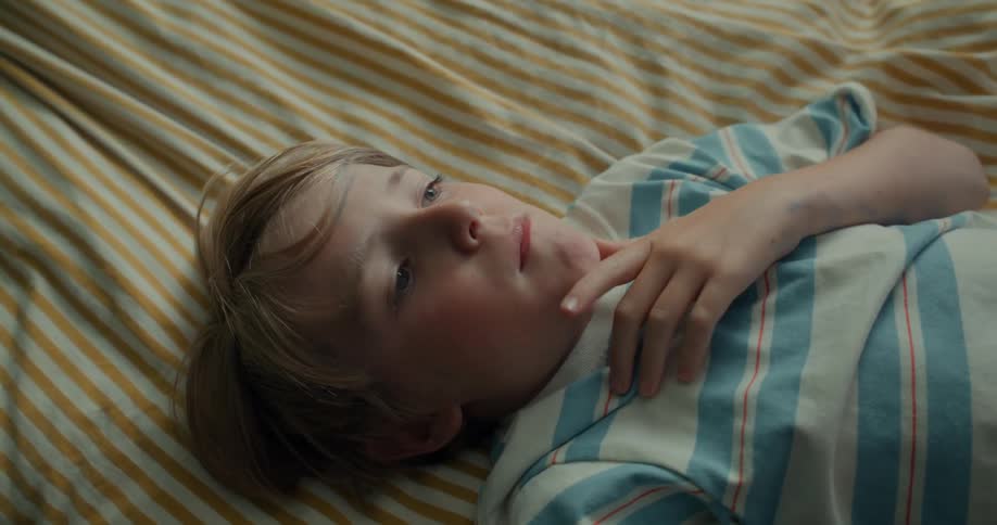 Boy lying down looking up thoughtfully