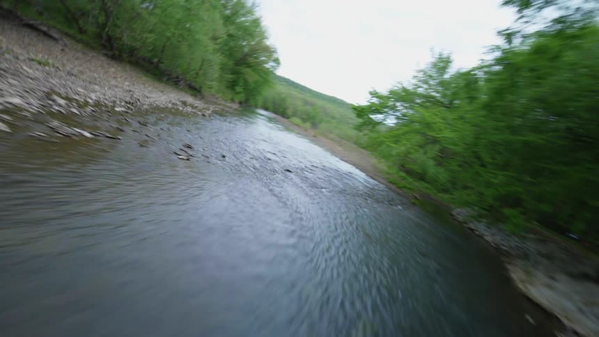 A river meanders through a forest and past a rural home in Arkansas