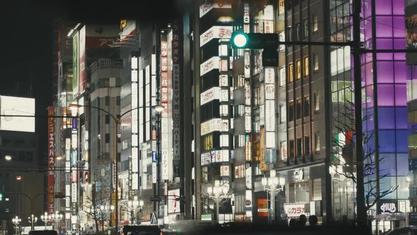 Downtown Tokyo Shinjuku is lit up with taxi cabs and bright signs with Japanese letters