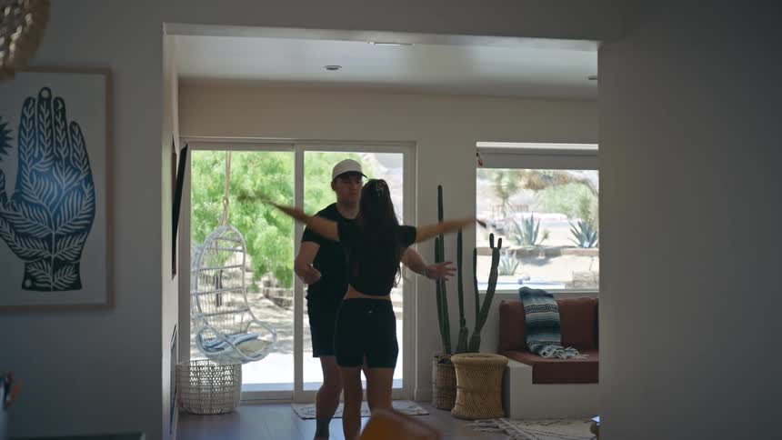 Man and woman indoors dancing a choreography together