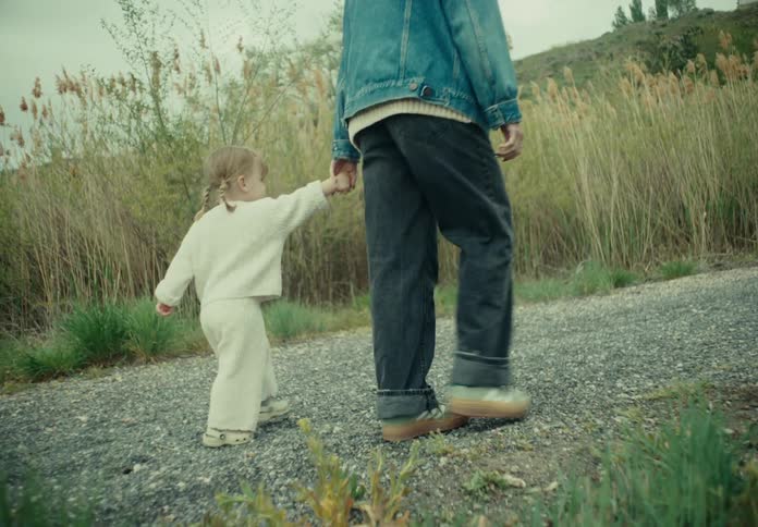 A family takes a stroll along a path through grasslands
