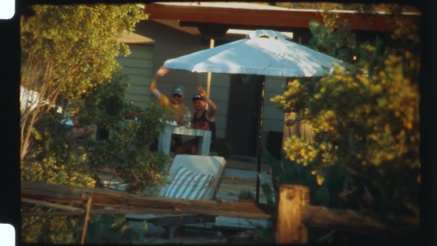 Two people sitting on a porch of a house are signing forward