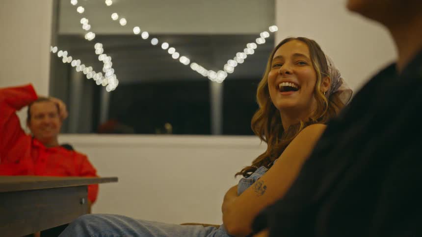 Three people sitting in a room smiling and talking