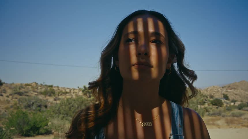 Portrait of a young woman in a natural environment with mountains and a blue sky in the background