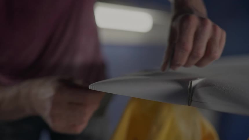 A man is sanding a board