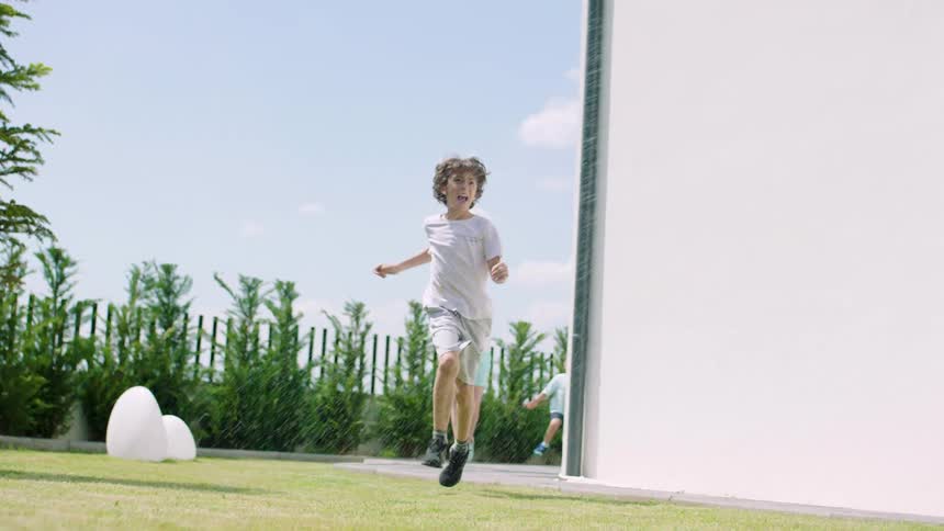 Three small children running after a white dog