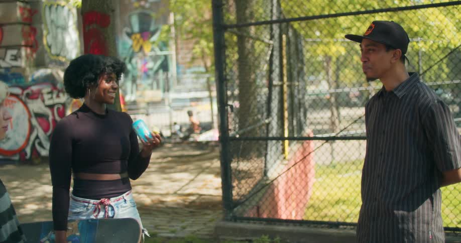 Man and two smiling women talking at an urban skate park