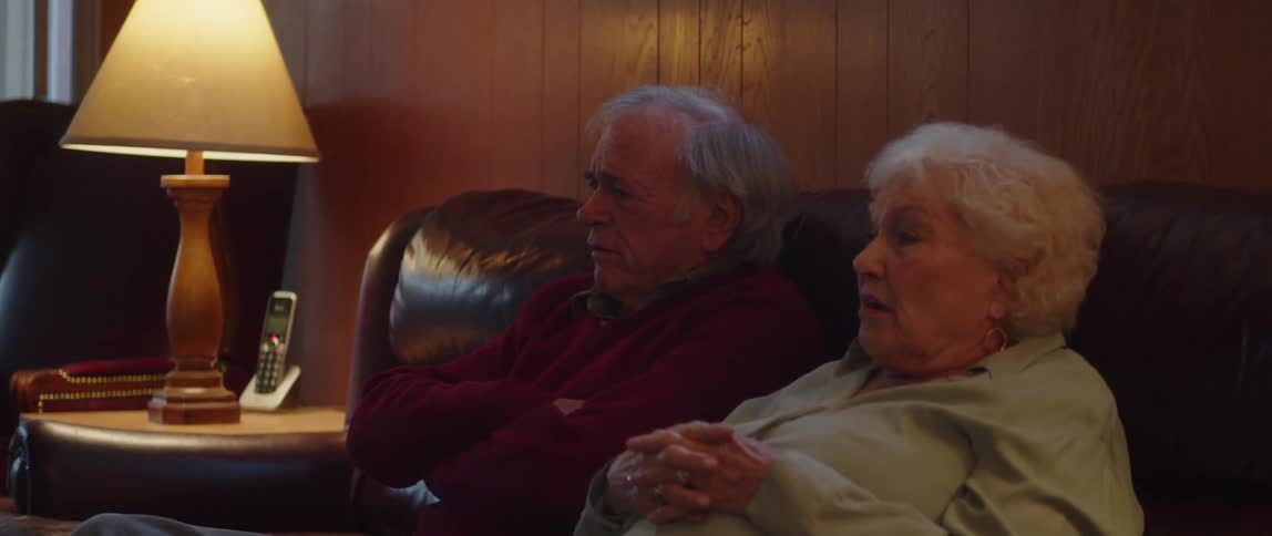 A couple talk while watching something