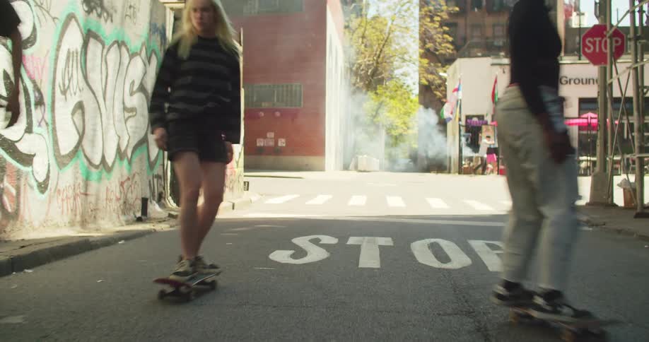 Three friends skateboarding on a street