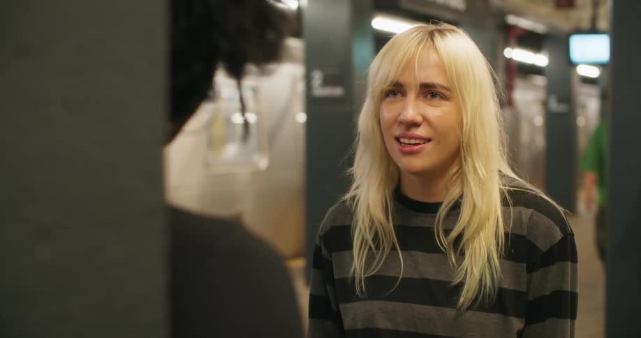 Two friends talking in a subway station