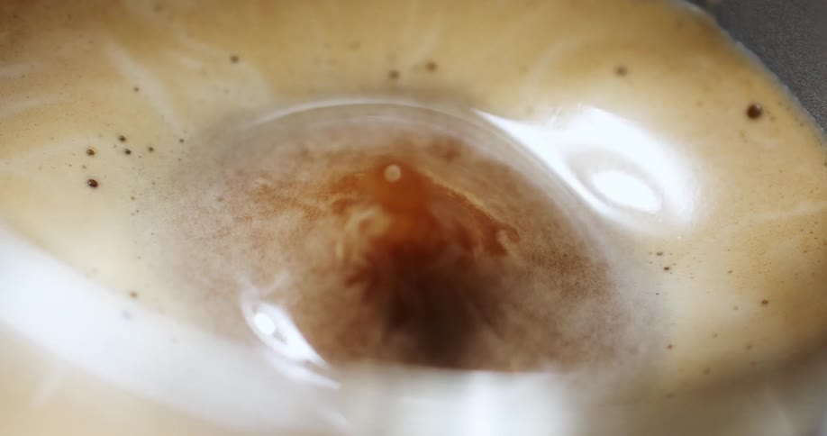 Droplets falling into a cup of coffee