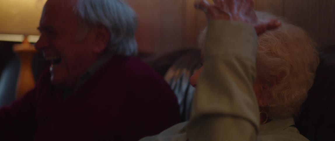 Elderly people sitting in the living room laughing