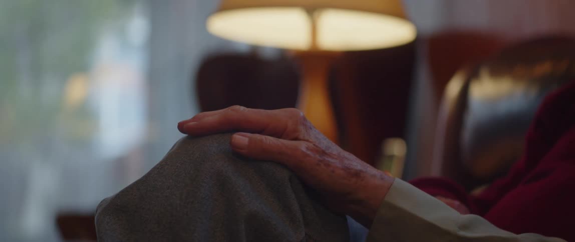 Elderly womans hand on another persons knee