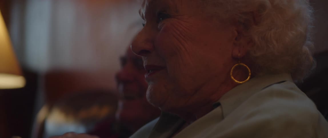 Elderly couple sitting on a sofa laughing