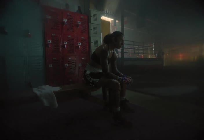 Woman with a body wet with sweat sitting on a bench next to a boxing ring