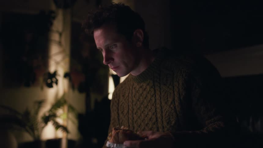 Man in a dark room concentrated eating a snack