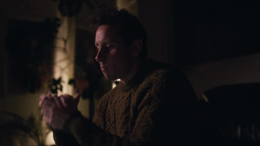 Man sitting in a dimly lit office works on a laptop
