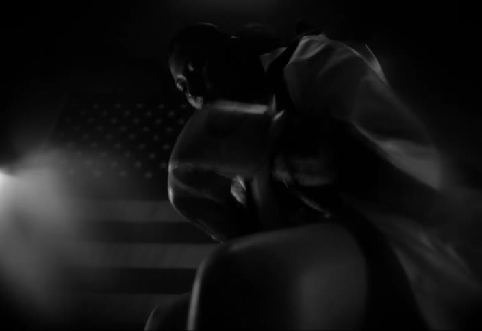 Female boxer hits her gloved hands together while sitting and waiting for the match to start
