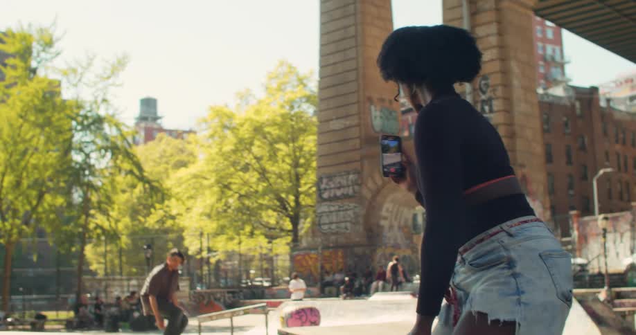 Man on a skateboard almost collides with a woman on a skateboard as they pass each other