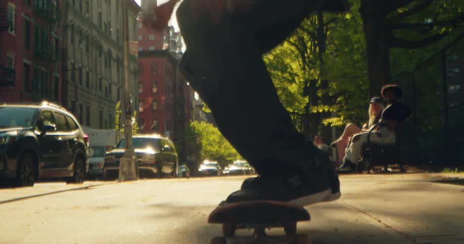 A male skater jumping over the camera with his skateboard in the city
