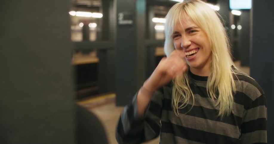 Two friends in a metro station talking smiling