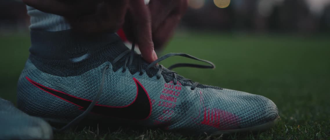 Closeup of a pair of hands tying a nike soccer cleat