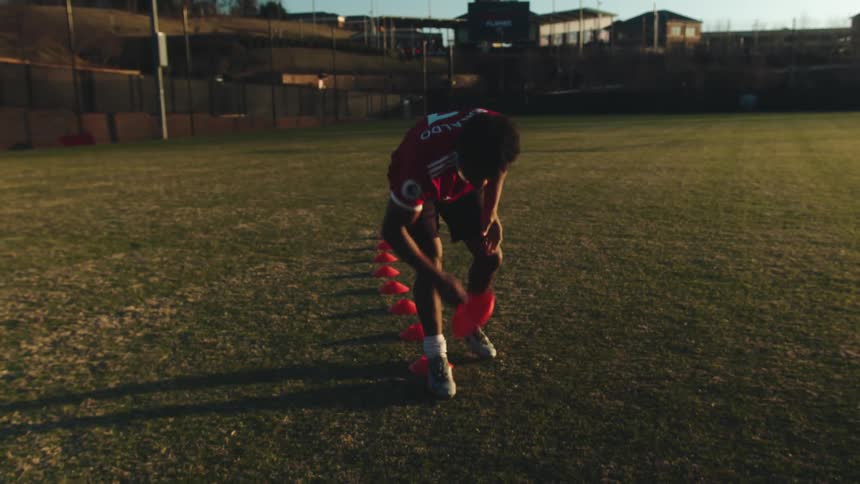 A man places markers on the soccer field
