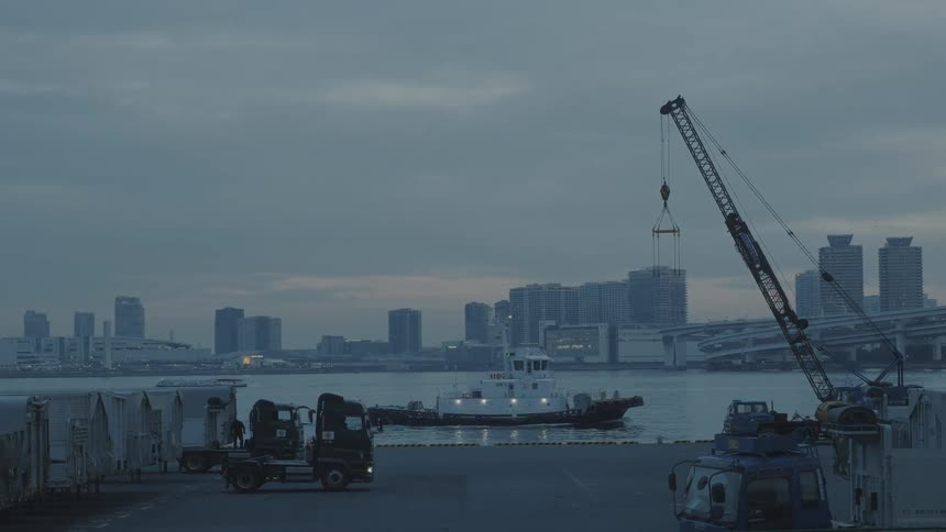 A tug boat passes by the city shore