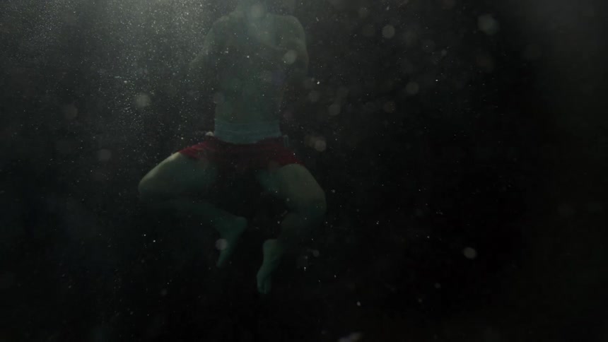 A man swims up through the water