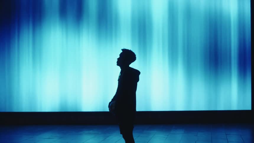 A male soccer player in silhouette standing on a stage