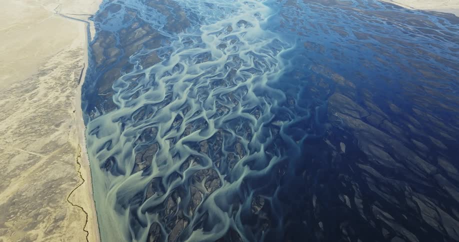 Aerial panorama of a blue sea with glaciers and gray terrain around it