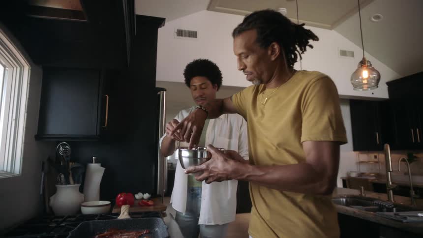 Two men are cooking in the kitchen