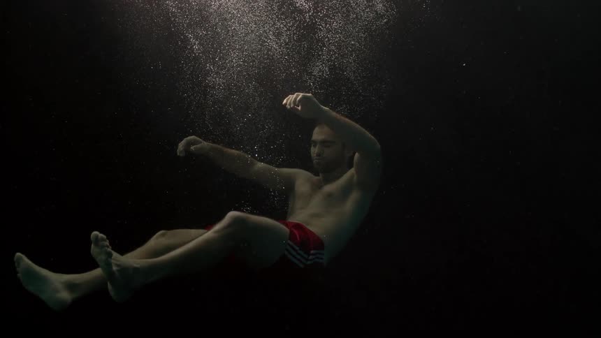 A man sinks in the dark water
