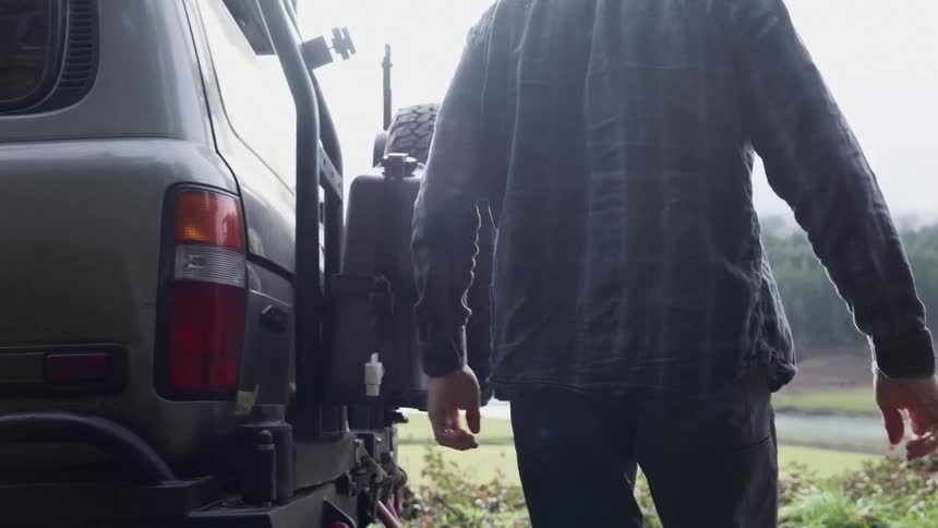 Man getting out of the truck and heading towards the trunk