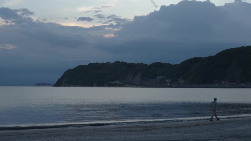 Person walking on the beach sand one morning