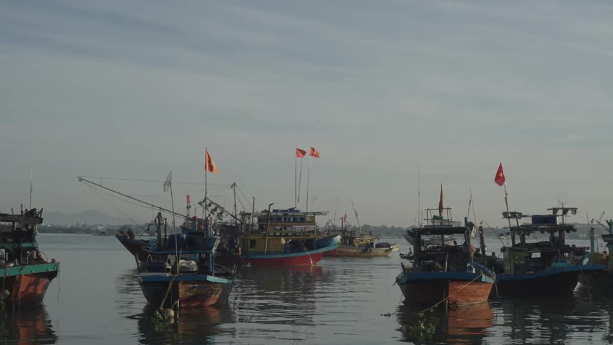 A group of colorful fishing boats floats on calm water