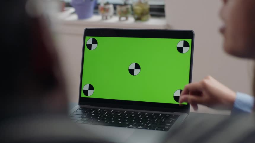 Two people around an open laptop