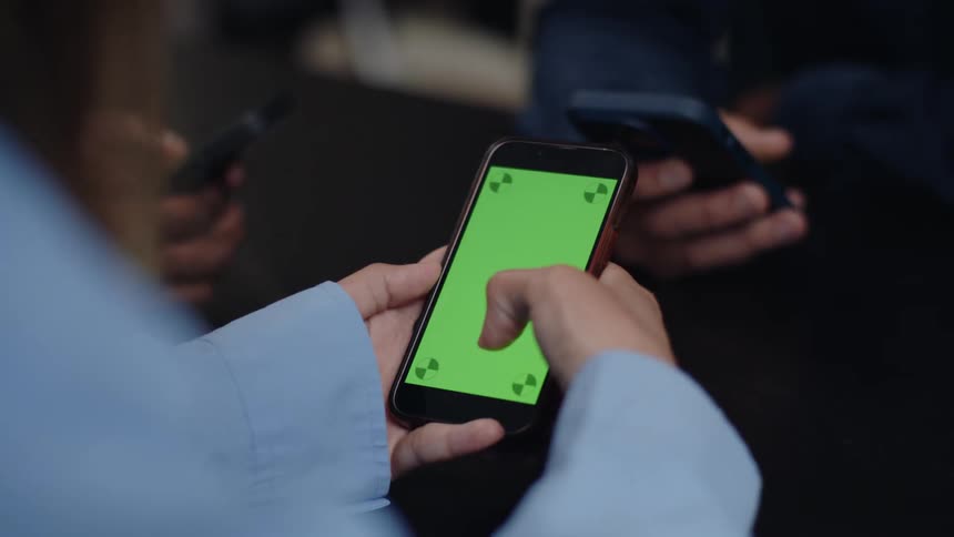 Closeup of peoples hands using and using cell phones