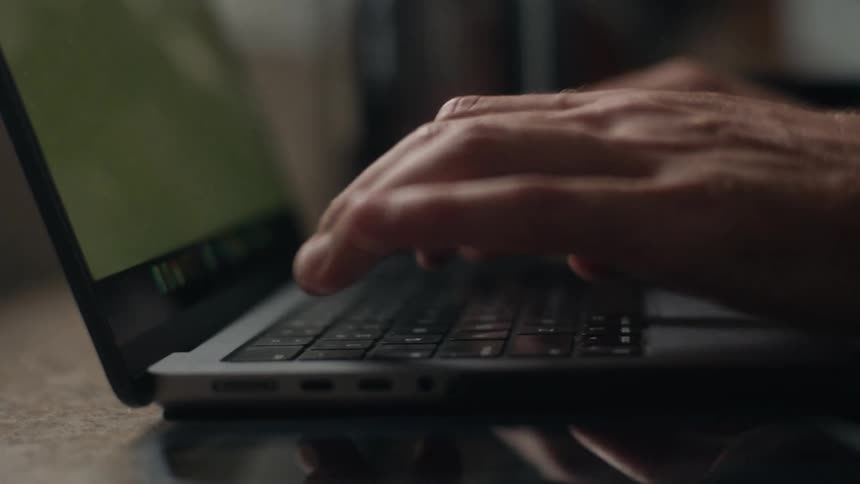 Hands typing on a laptop keyboard