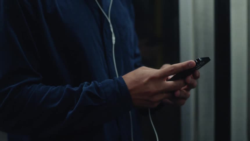 Man using and typing on an iphone while on a moving train