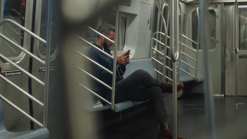 A man is using his phone while riding the train