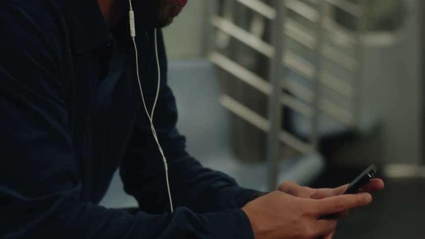Man sitting on a train using his cell phone