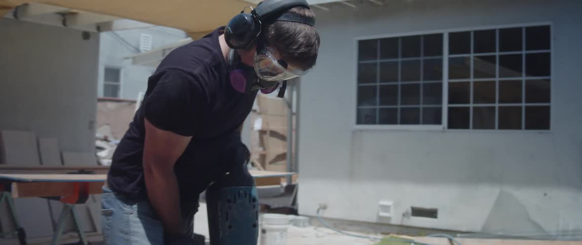 Male worker uses a jackhammer at a construction site