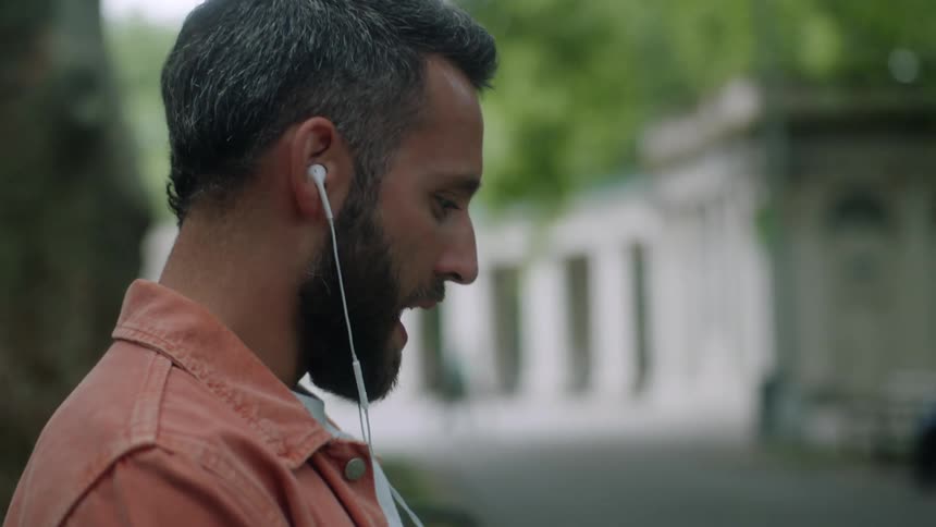 Man using earbuds gestures while on a video call