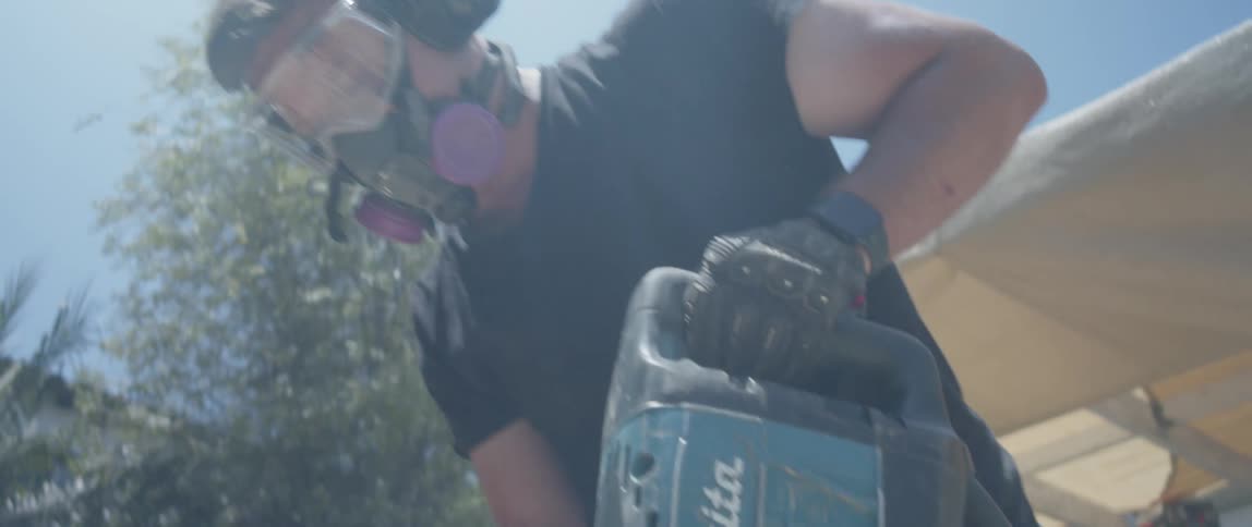 Man with protective mask working with a jackhammer